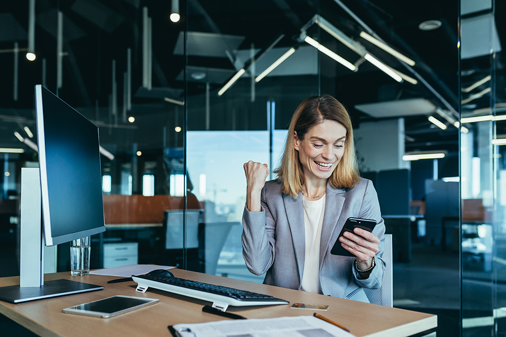 eine Geschäftsfrau die B2B Telefonakquise durchführt und hat gerade ein erfolgreiches Gespräch abgeschlossen