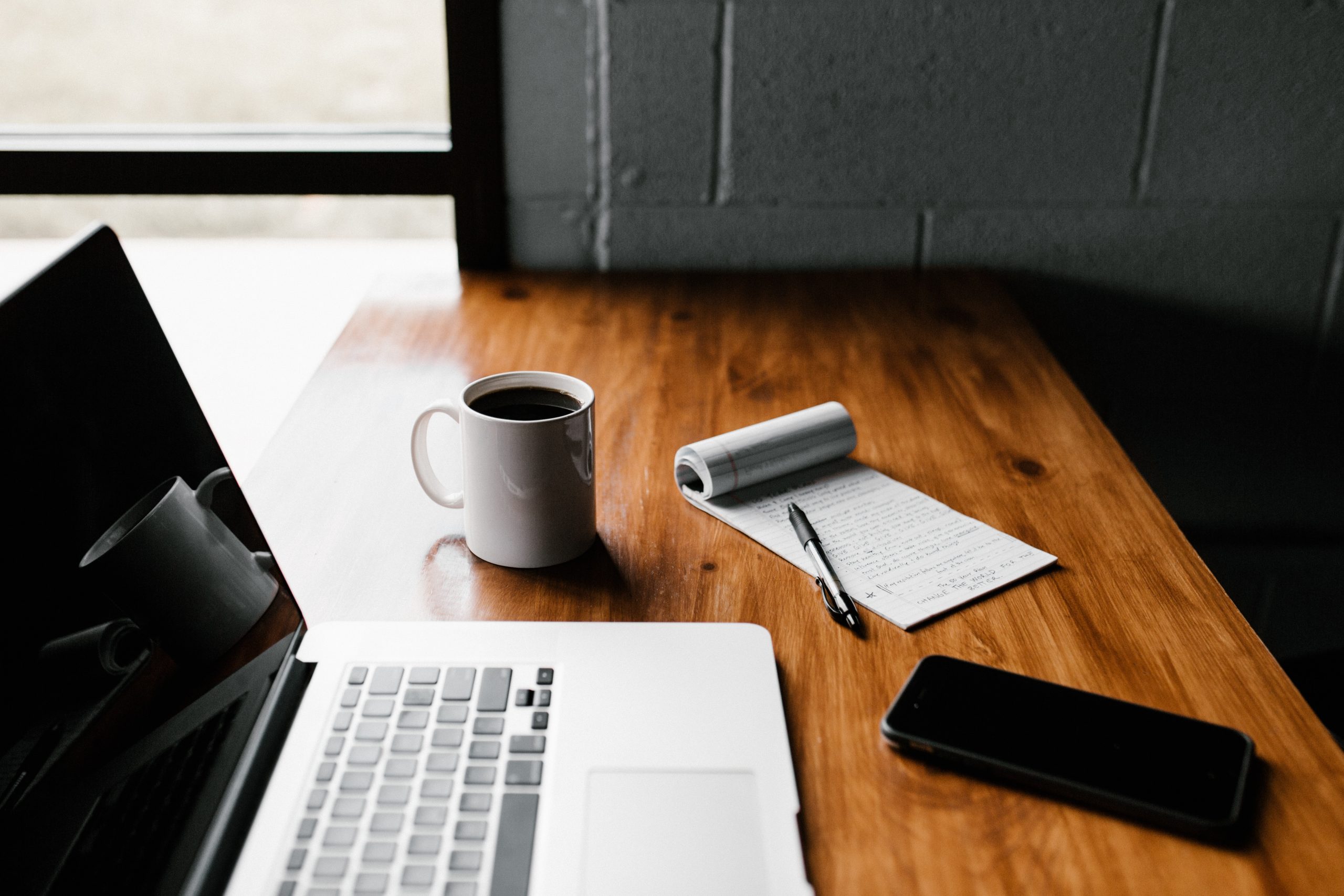 Laptop avec une tasse de café et un bloc-note