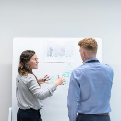 2 personnes devant un tableau de présentation