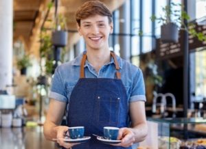 barista avec deux cafés dans les mains